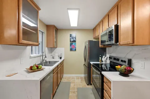 a kitchen with stainless steel appliances granite countertop a sink stove and refrigerator