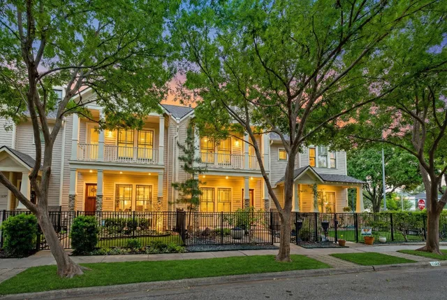 a front view of residential houses with yard and green space