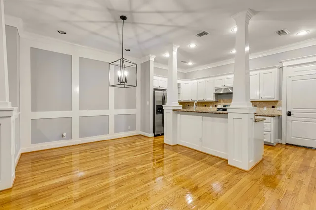 a view of kitchen with white cabinets and stainless steel appliances