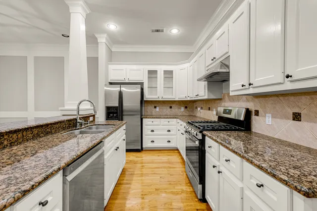 a kitchen with granite countertop a sink stove and cabinets