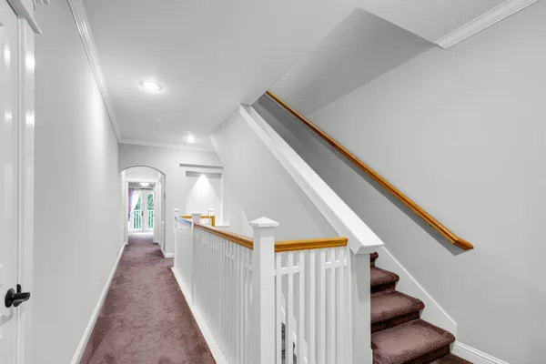 a view of a hallway with entryway and stairs