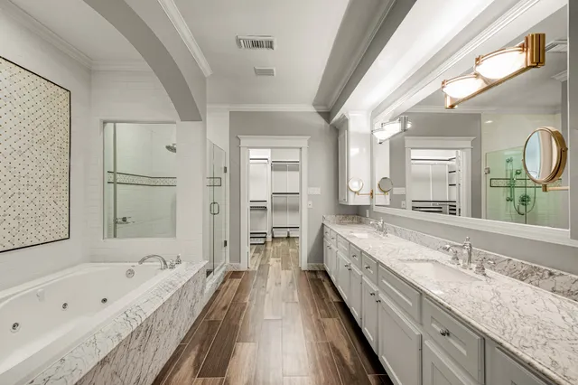 a spacious bathroom with a granite countertop tub double vanity sink and a large mirror