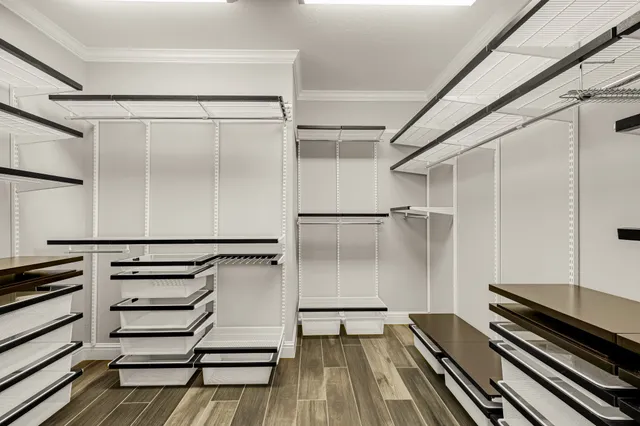 a view of an empty room with wooden floor and stairs