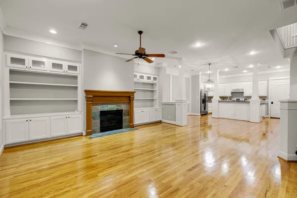 a view of a livingroom with a fireplace a chandelier and wooden floor