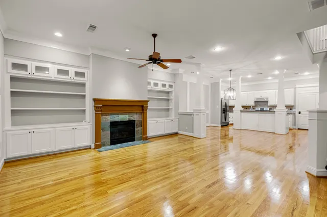 a view of a livingroom with a fireplace a chandelier and wooden floor