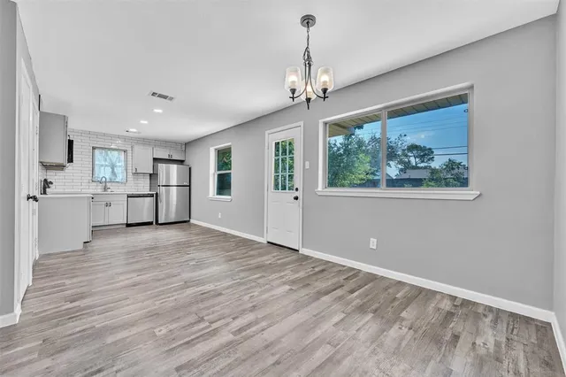 a view of a big room with wooden floor windows and cabinet