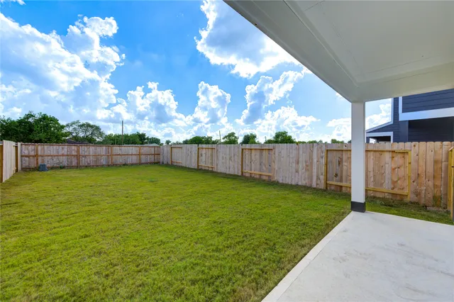 a view of yard with swimming pool and wooden fence