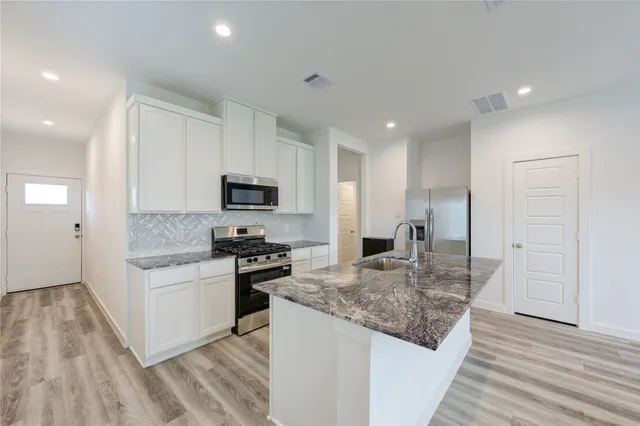 a kitchen with granite countertop stainless steel appliances and wooden cabinets
