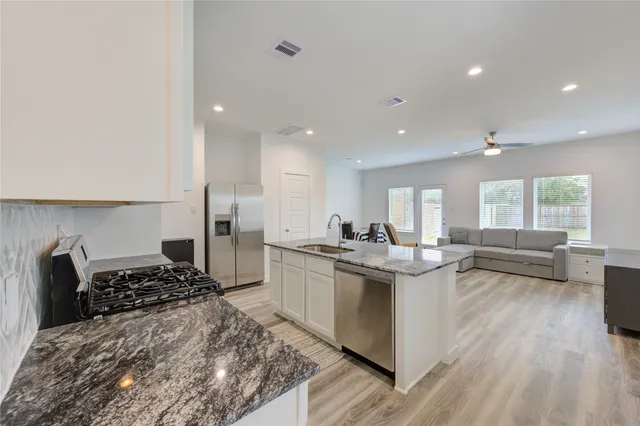 a kitchen with stainless steel appliances granite countertop a stove and a refrigerator