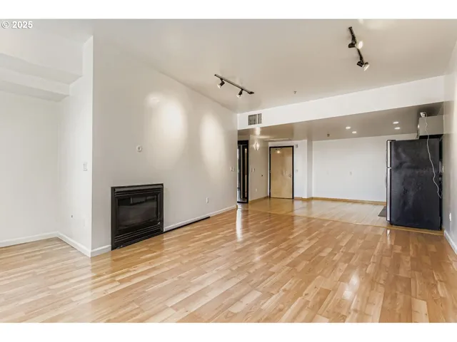 a view of an empty room with wooden floor