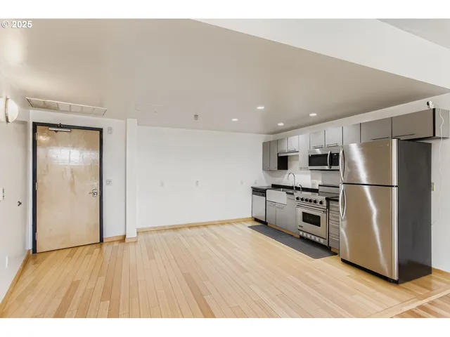 a kitchen with stainless steel appliances granite countertop a refrigerator a stove top oven a sink and dishwasher