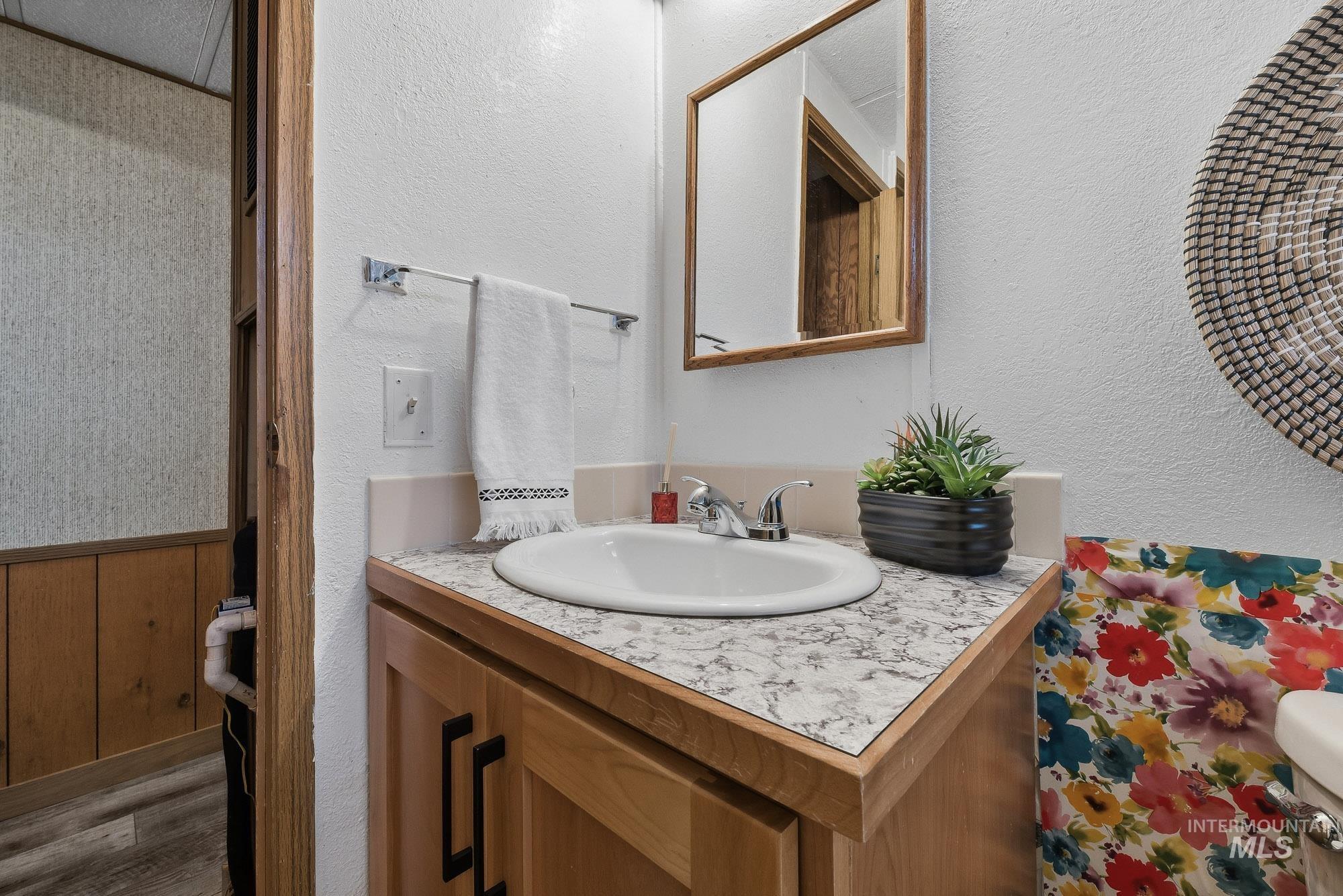 5200 Midway, Unit TRIR 20 Caldwell, ID 83607 - Photo 27 of 31 Half bathroom with a textured wall, vanity, and wood finished floors