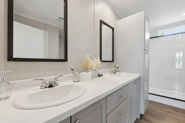 a bathroom with double sink and a mirror