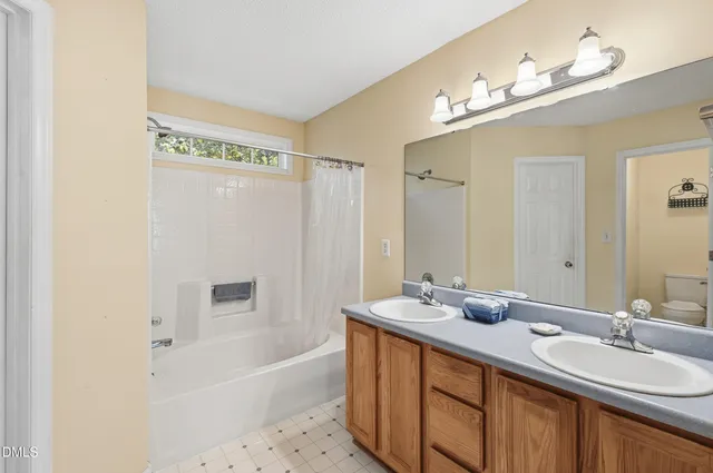 a bathroom with a tub a sink and mirror