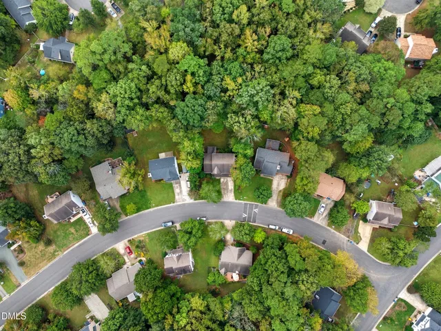 an aerial view of a house with yard and green space