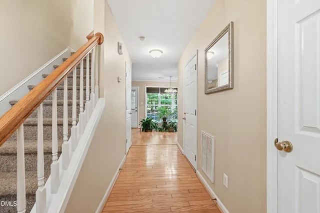 a view of a hallway with wooden floor and staircase