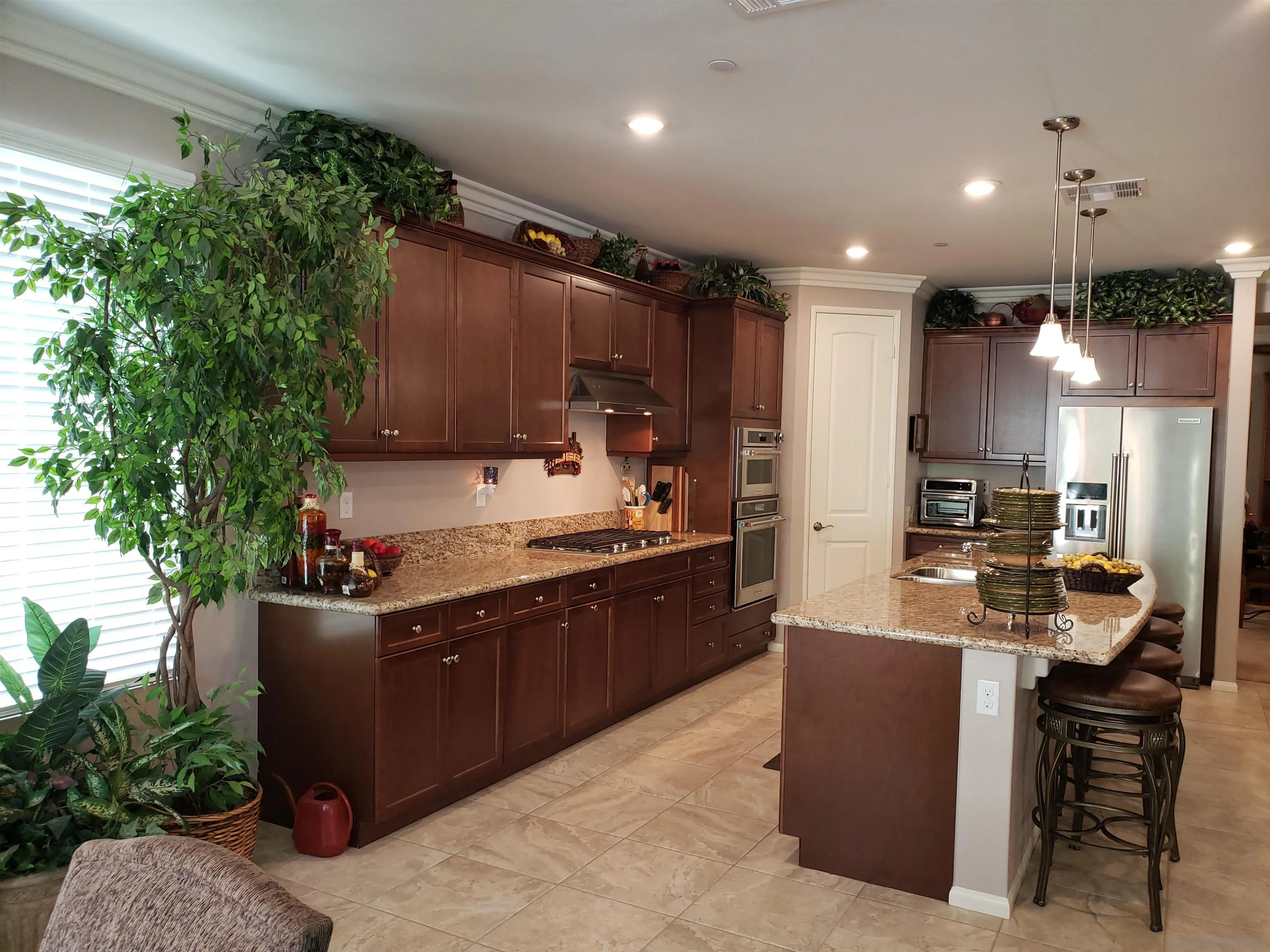 1624 Paseo Diamonte Hemet, CA 92545 - Photo 9 of 35 a large kitchen with stainless steel appliances kitchen island granite countertop a sink and cabinets