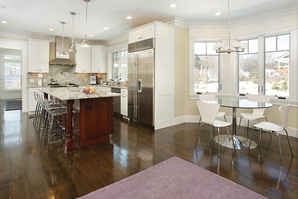 25 Marthas Lane Brookline, MA 02467 - Photo 2 of 10 a kitchen with stainless steel appliances granite countertop a table chairs stove a refrigerator and a dining table with wooden floor