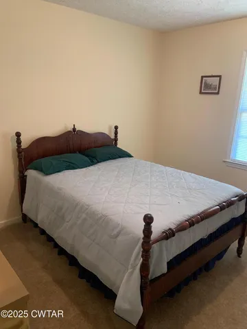 a bed sitting in a bedroom and chair