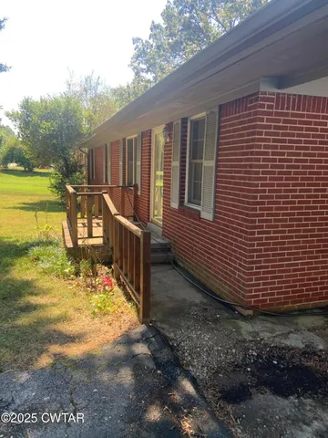 a view of a house with backyard and deck