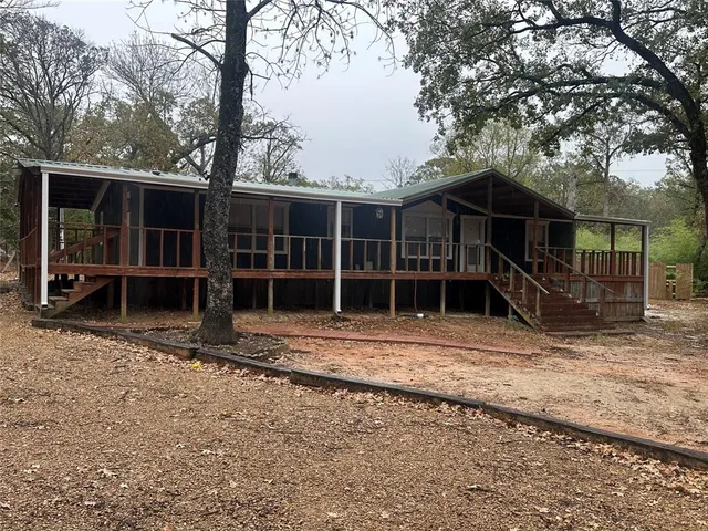 a view of a house with a yard and large tree