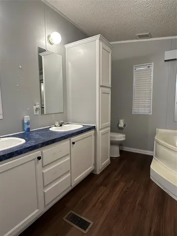 a bathroom with a granite countertop sink toilet and mirror