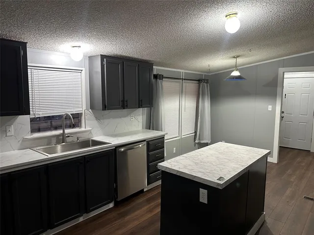 a kitchen with a sink a refrigerator and cabinets