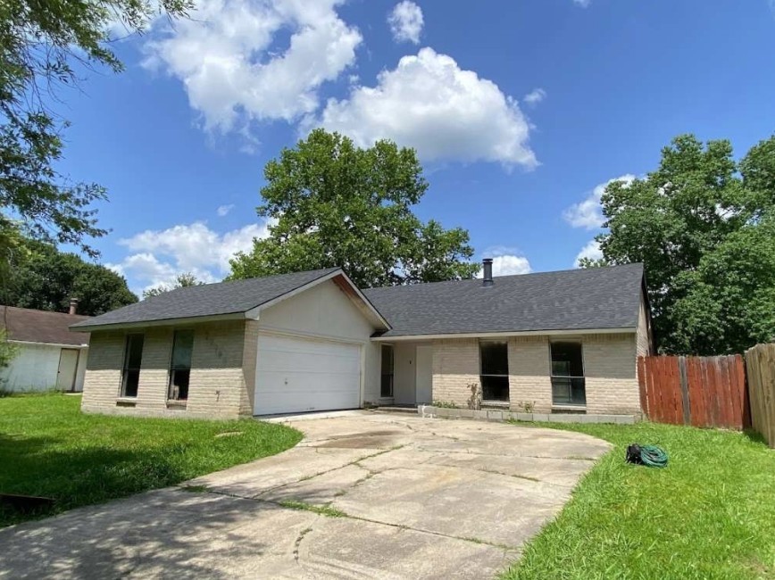a front view of a house with a garden and trees