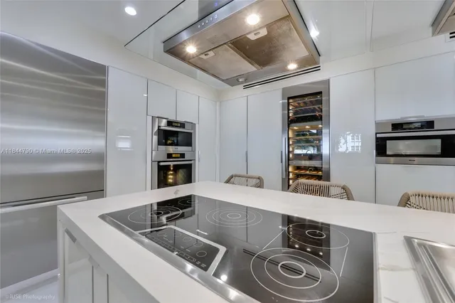 a kitchen with stainless steel appliances granite countertop a sink and a refrigerator