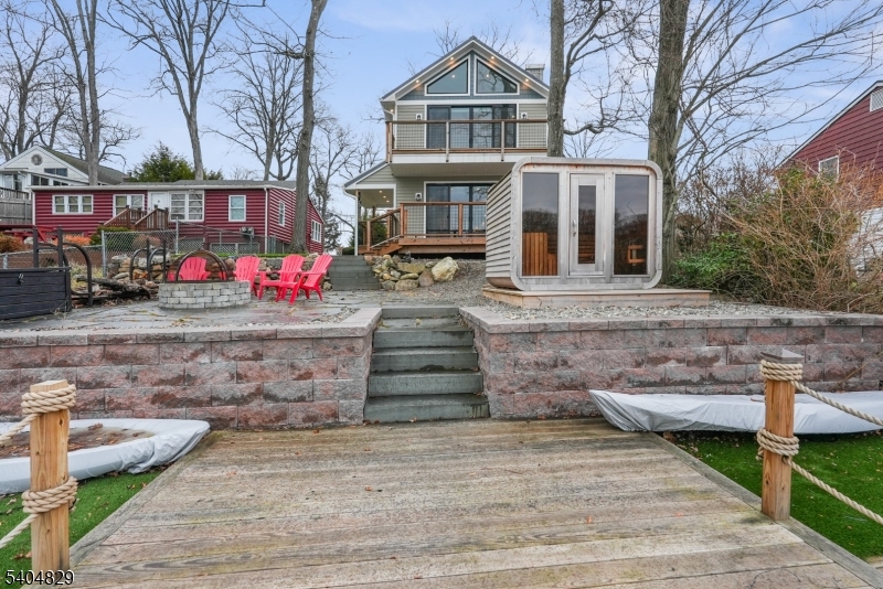 71 Witte Road West Milford, NJ 07421 - Photo 34 of 42 a view of a white house with large windows and a table and chairs