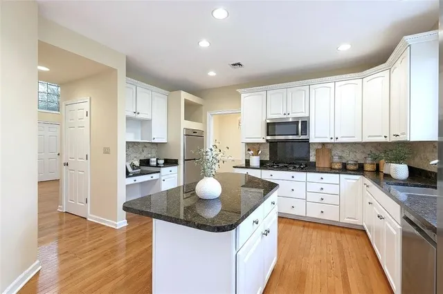 a kitchen with granite countertop sink stove and refrigerator