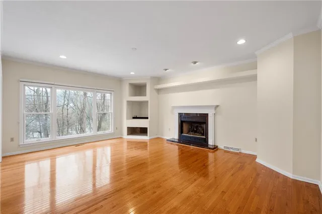 a view of an empty room with a window and fireplace