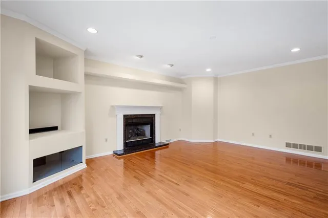 a view of empty room with wooden floor and fireplace