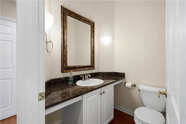 a bathroom with a granite countertop toilet sink and mirror