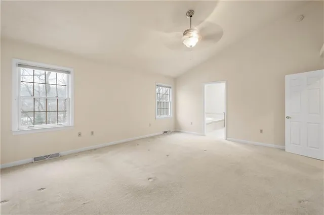an empty room with windows and fan