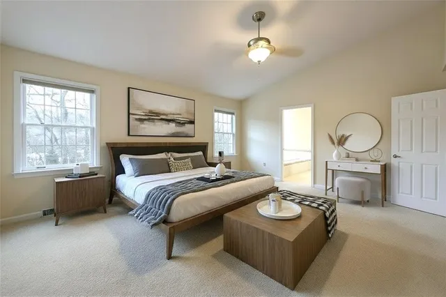 a spacious bedroom with a bed a dresser with mirror