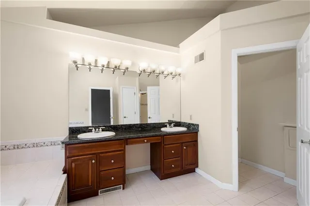 a room with a chandelier a sink and a mirror