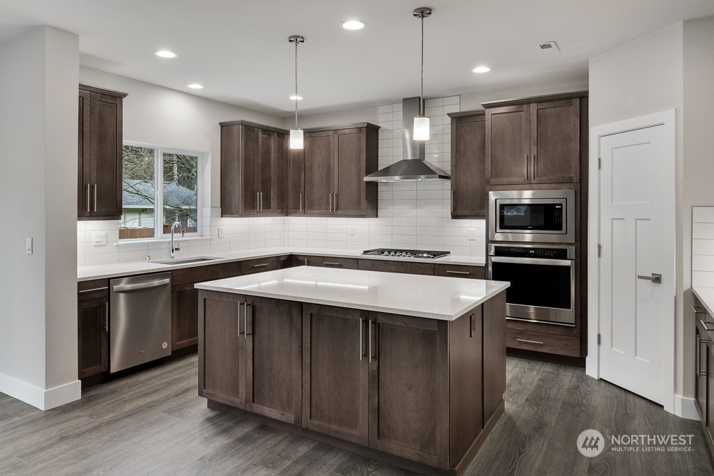 4012 171st Place Southeast Bothell, WA 98012 - Photo 12 of 28 a kitchen with kitchen island stainless steel appliances a sink stove and refrigerator