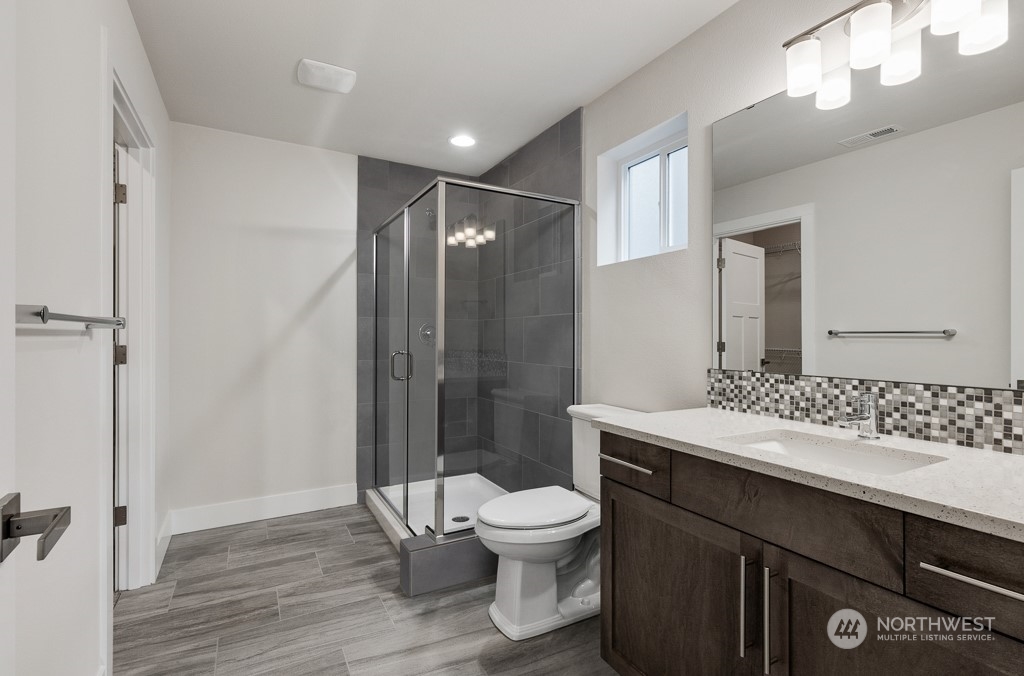 4012 171st Place Southeast Bothell, WA 98012 - Photo 5 of 28 a bathroom with a sink a toilet a mirror and shower