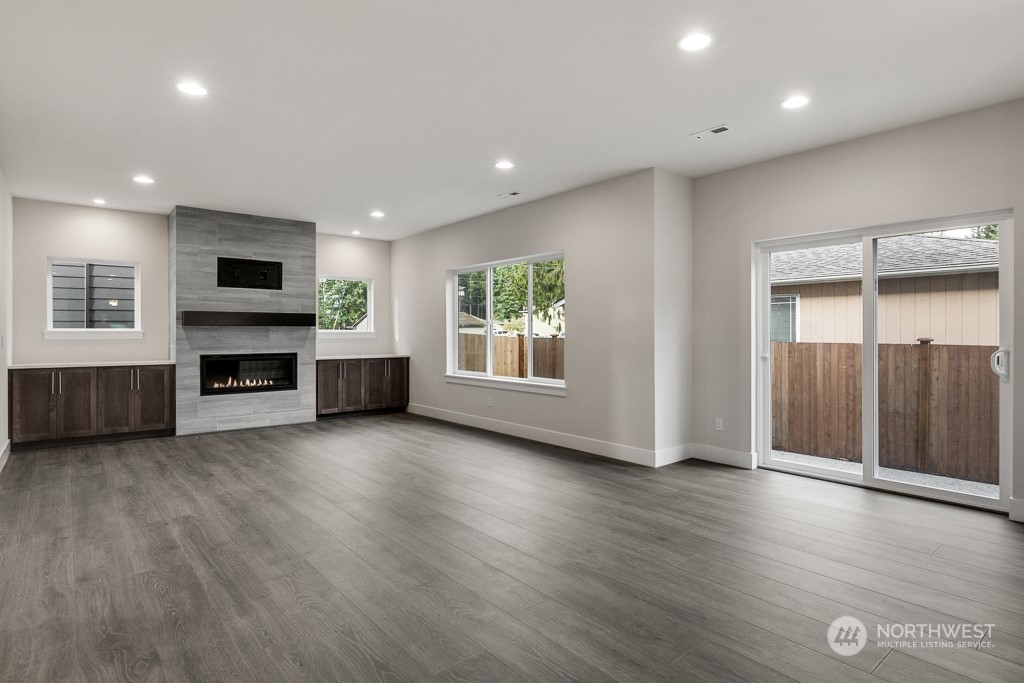 4012 171st Place Southeast Bothell, WA 98012 - Photo 10 of 28 an empty room with wooden floor fireplace and windows