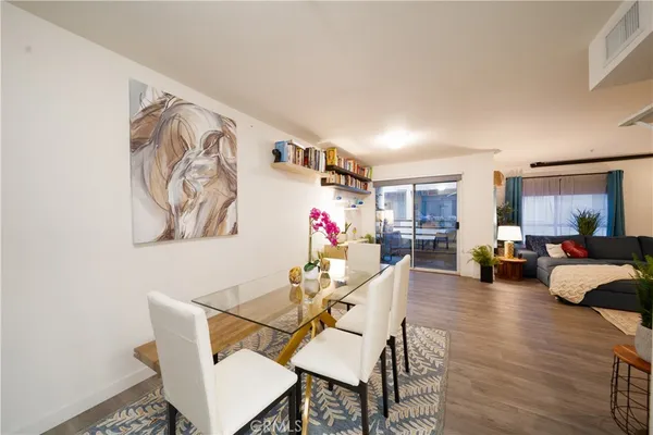 a living room with furniture and a refrigerator