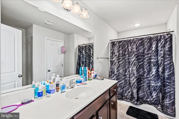 a bathroom with a sink vanity mirror and a bathtub