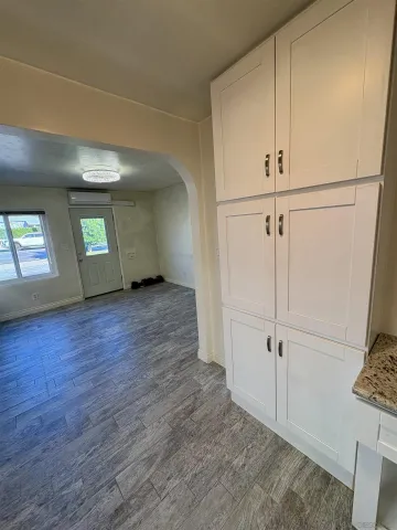 a view of an empty room with closet and windows