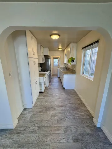 a view of a living room with furniture and a wooden floor
