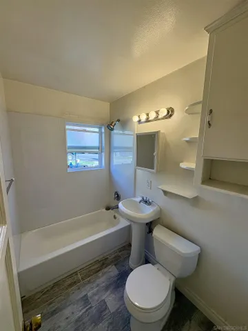 a bathroom with a toilet a sink and bathtub