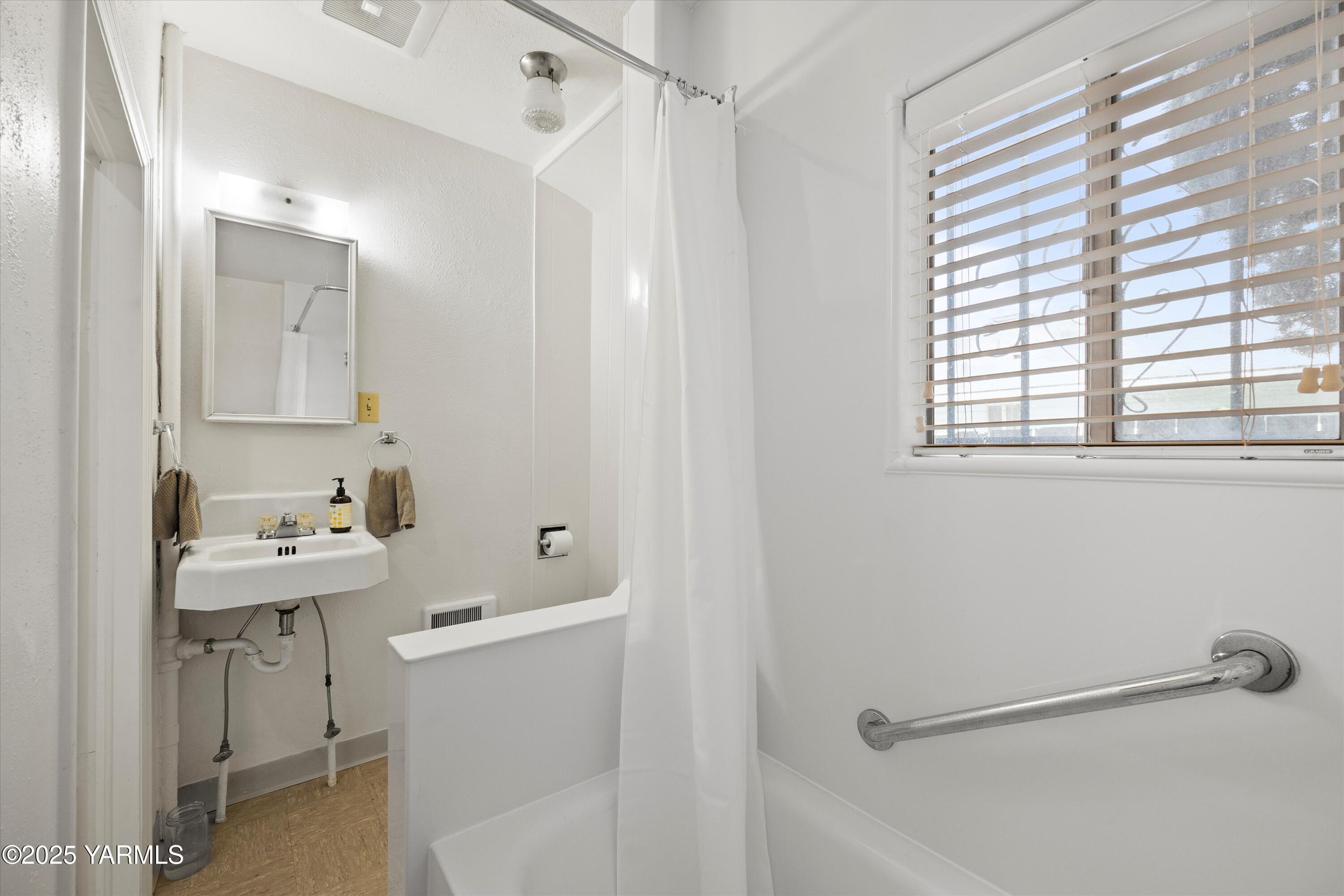 305 South 9th Street Yakima, WA 98901 - Photo 27 of 43 a bathroom with a sink a toilet and a mirror