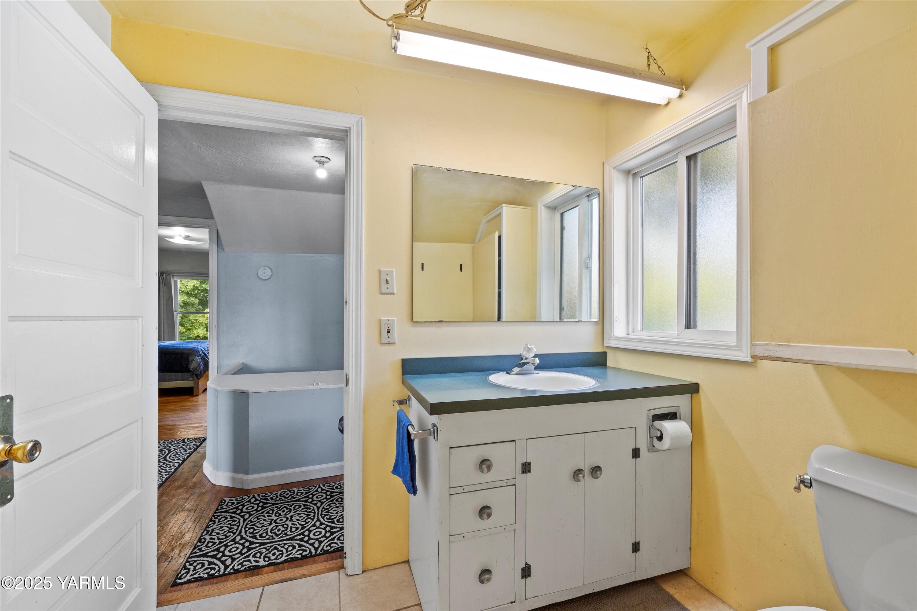 305 South 9th Street Yakima, WA 98901 - Photo 8 of 43 a bathroom with a granite countertop sink and a mirror