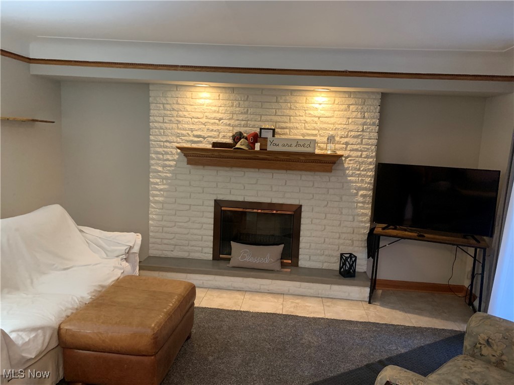 1590 Meadowlane Road Independence, OH 44131 - Photo 9 of 22 Living room featuring light tile patterned flooring and a brick fireplace