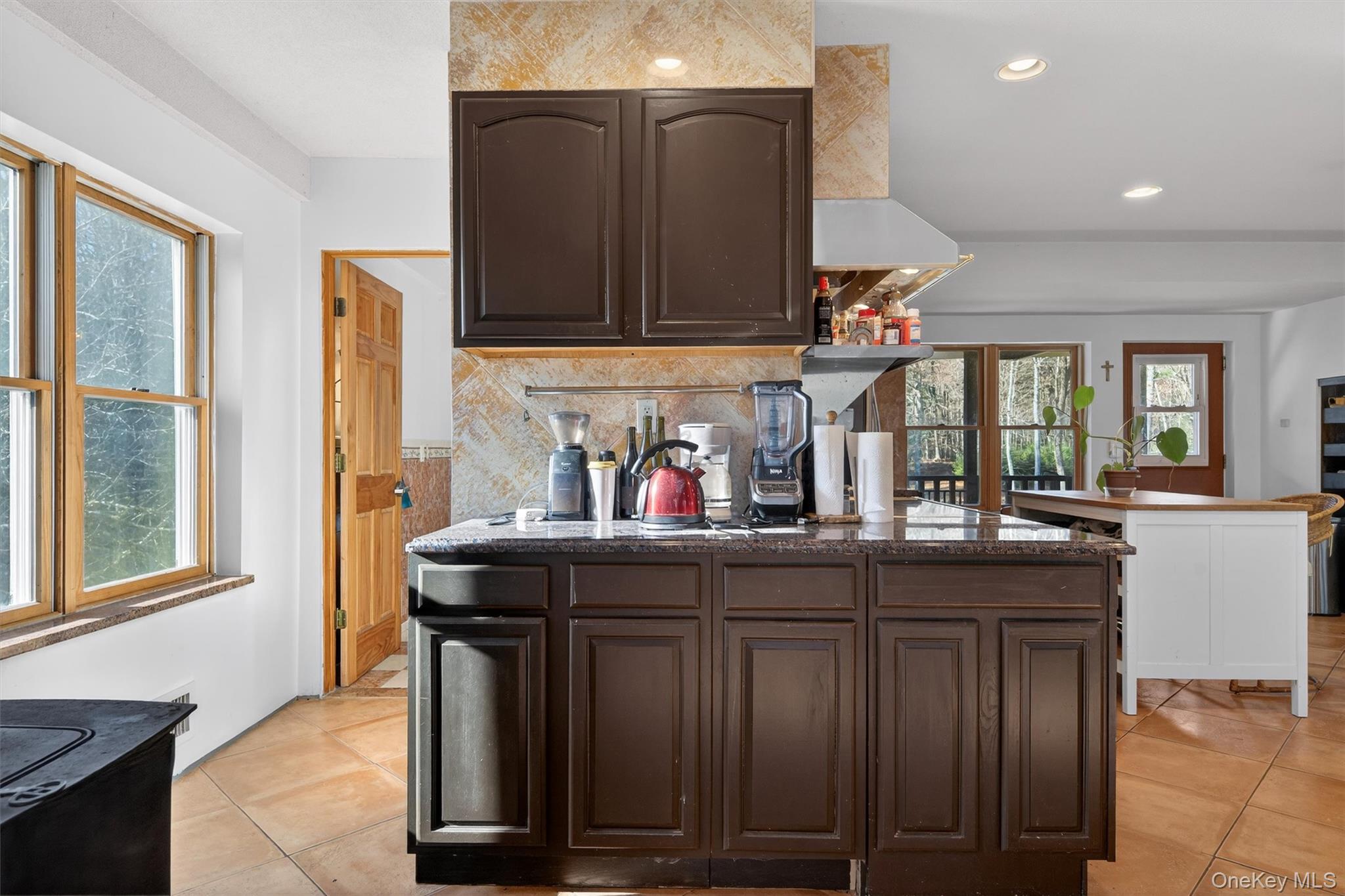 125 Dexheimer Road Narrowsburg, NY 12764 - Photo 13 of 50 Kitchen with dark brown cabinetry, decorative backsplash, light tile patterned flooring, recessed lighting, and dark stone countertops