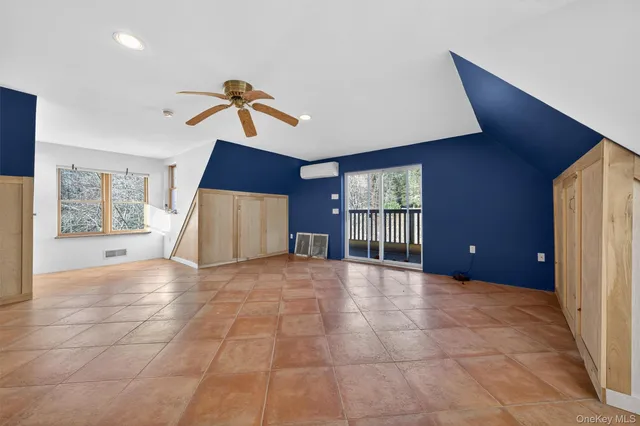 a view of an empty room with window and cabinet